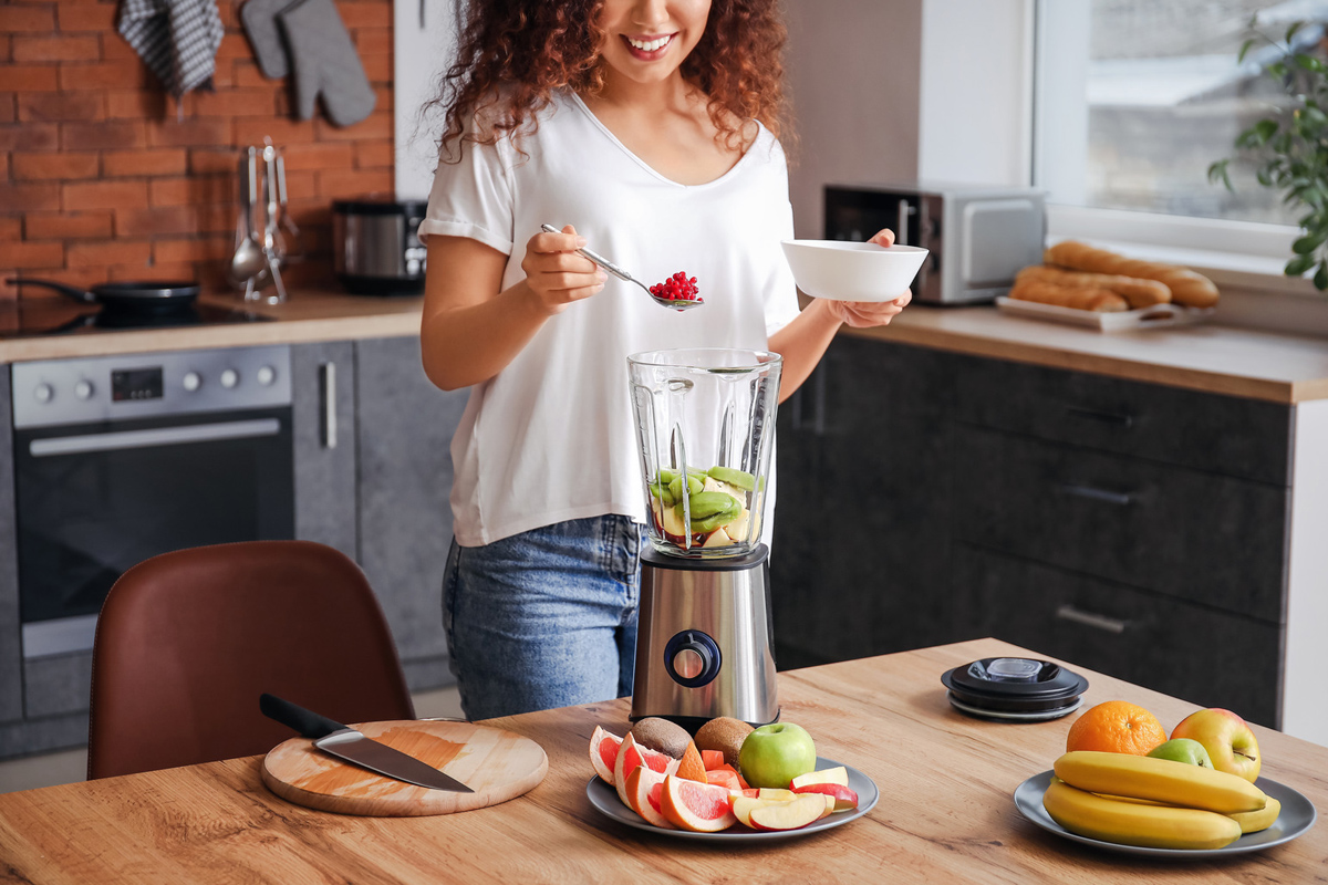 Femme préparant un smoothie dans sa cuisine