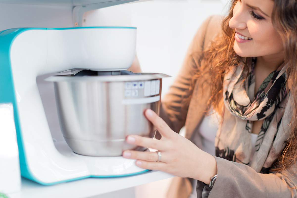 Femme qui range le robot de cuisine après l'avoir nettoyer